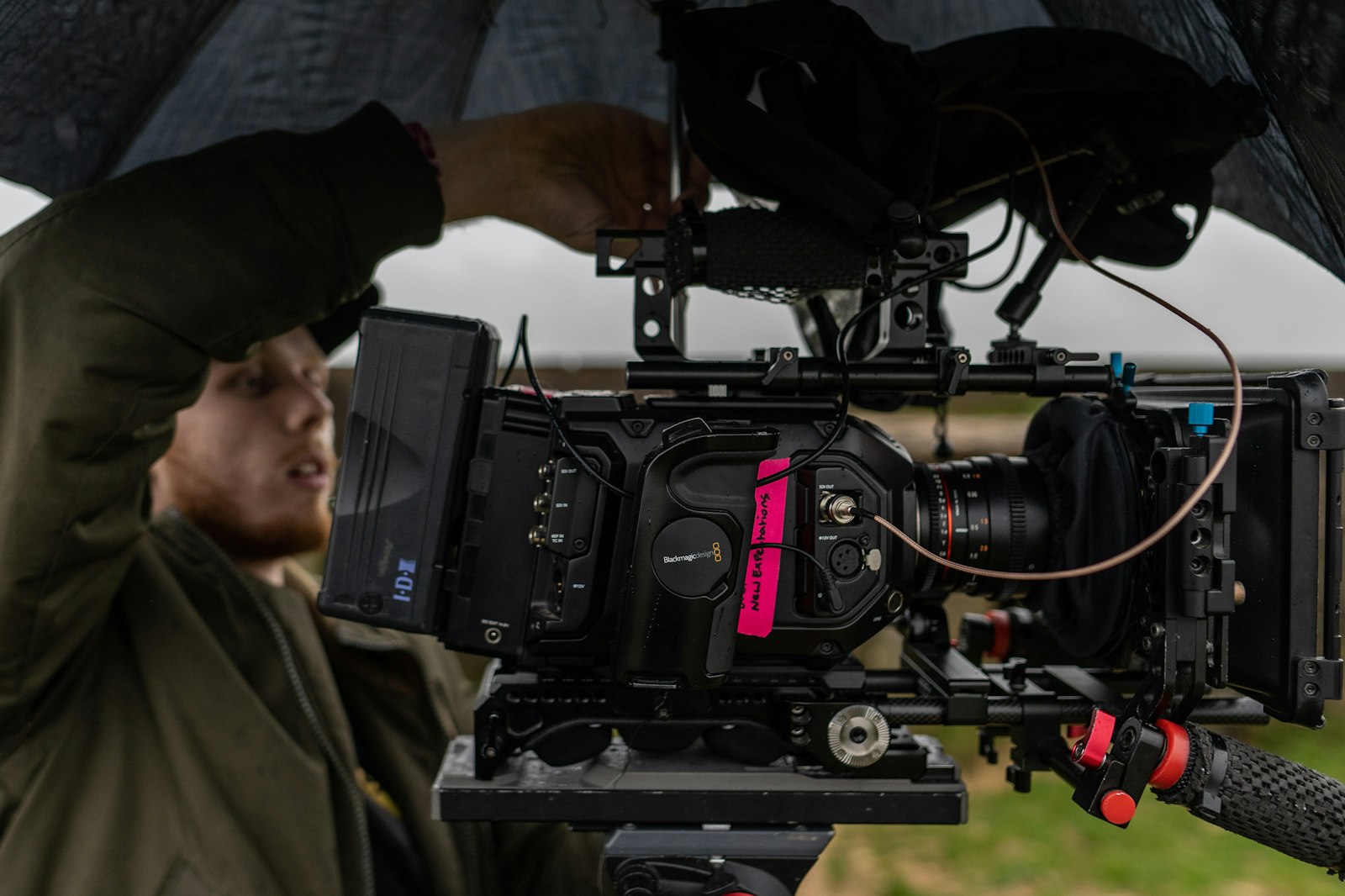 Assistant adjusting a professional cinema camera mounted on a tripod